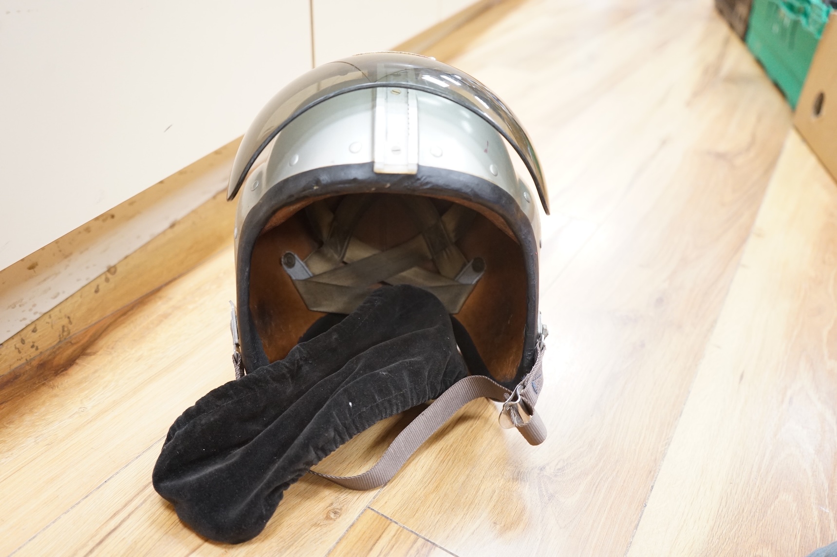 An early British jet aircraft RAF flying helmet, size 3 regular, dated 1958, with visor and visor cover, and original interior webbing, complete with inner cloth flight cap with built-in headphones and electrics and date